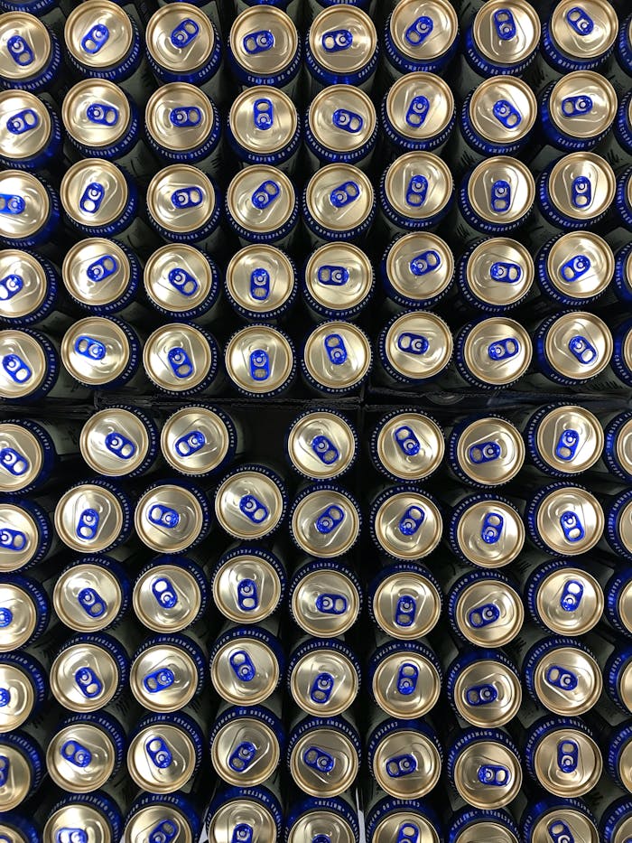 An overhead shot of aligned beverage cans displaying uniform tops in rows.