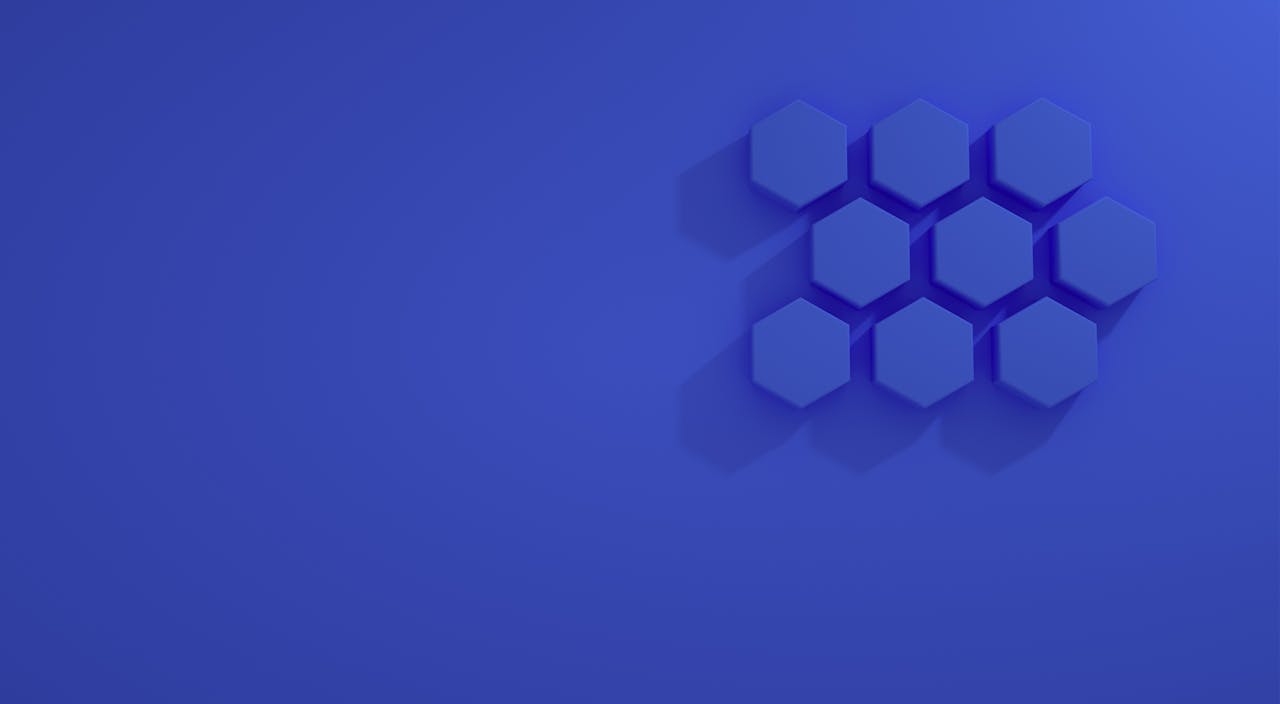 A minimalist abstract design featuring blue hexagons on a blue background.